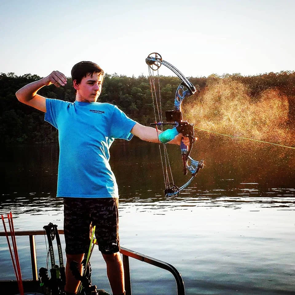 A bowfisher aiming from the Goldline boat during a daytime trip